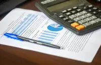 Калкулатор и отчет с графики върху бюро — изчисляване на цена за сайт
